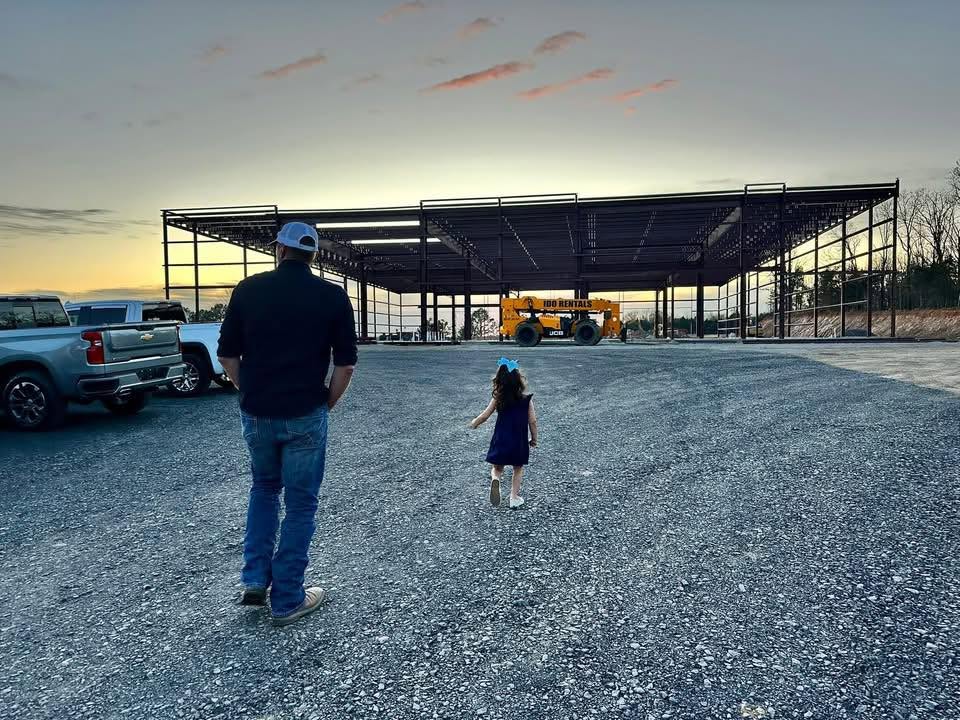 Next Phase Inc steel-frame building under construction at sunset
